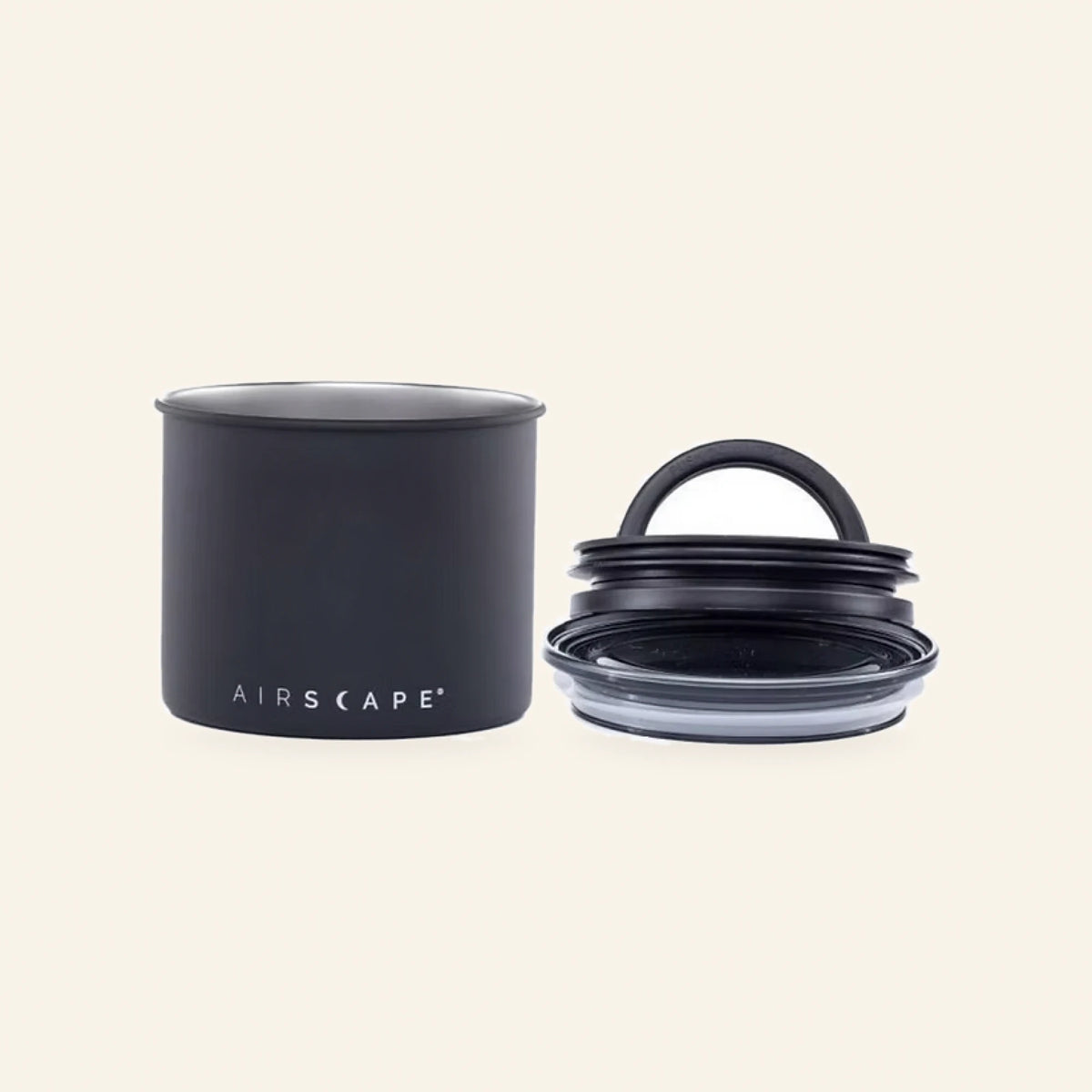 Kleine schwarze Airscape Kaffeedose mit abgenommenem Vakuumdeckel daneben
