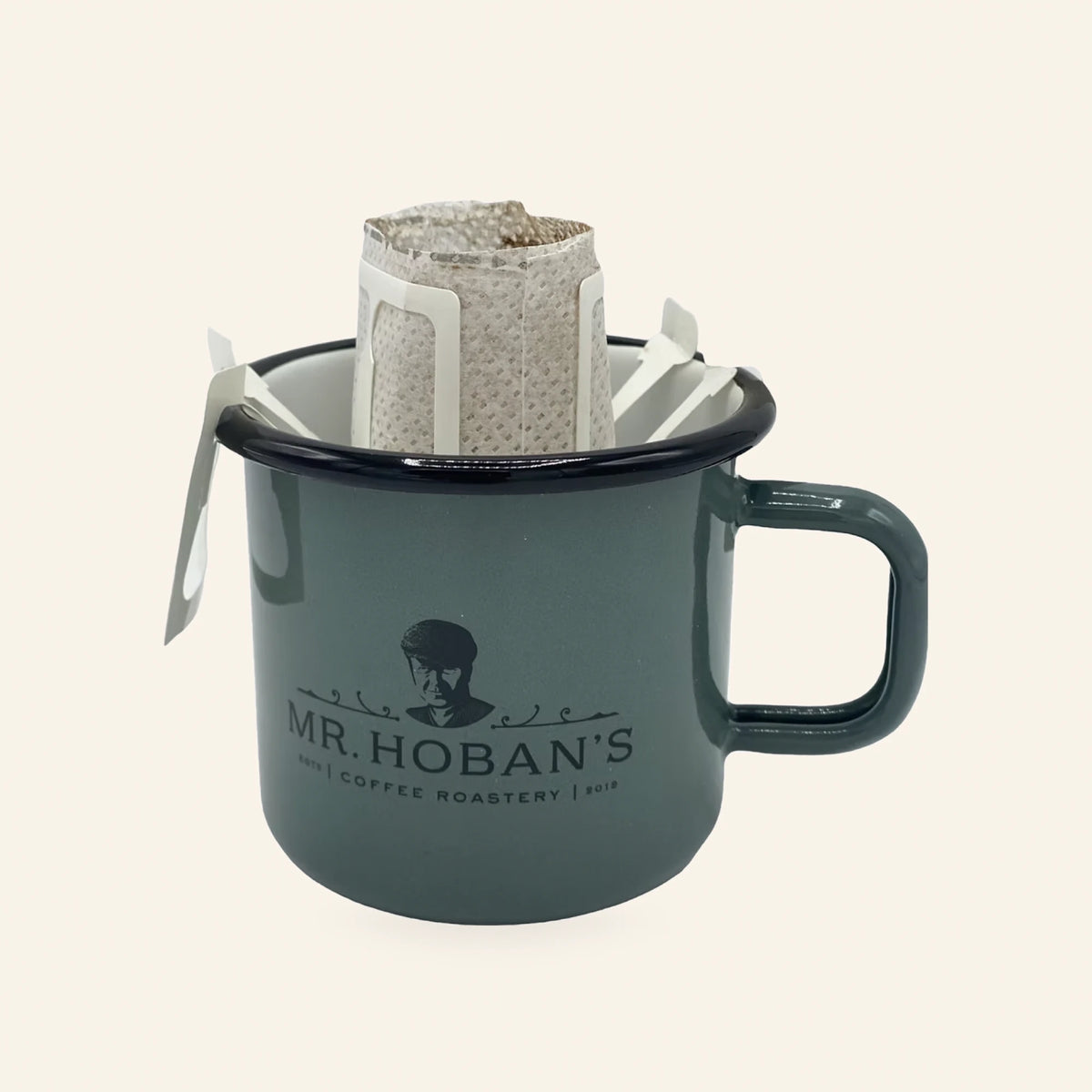Drip Bag eingehängt in einen grünen Mr. Hoban's Emaillebecher