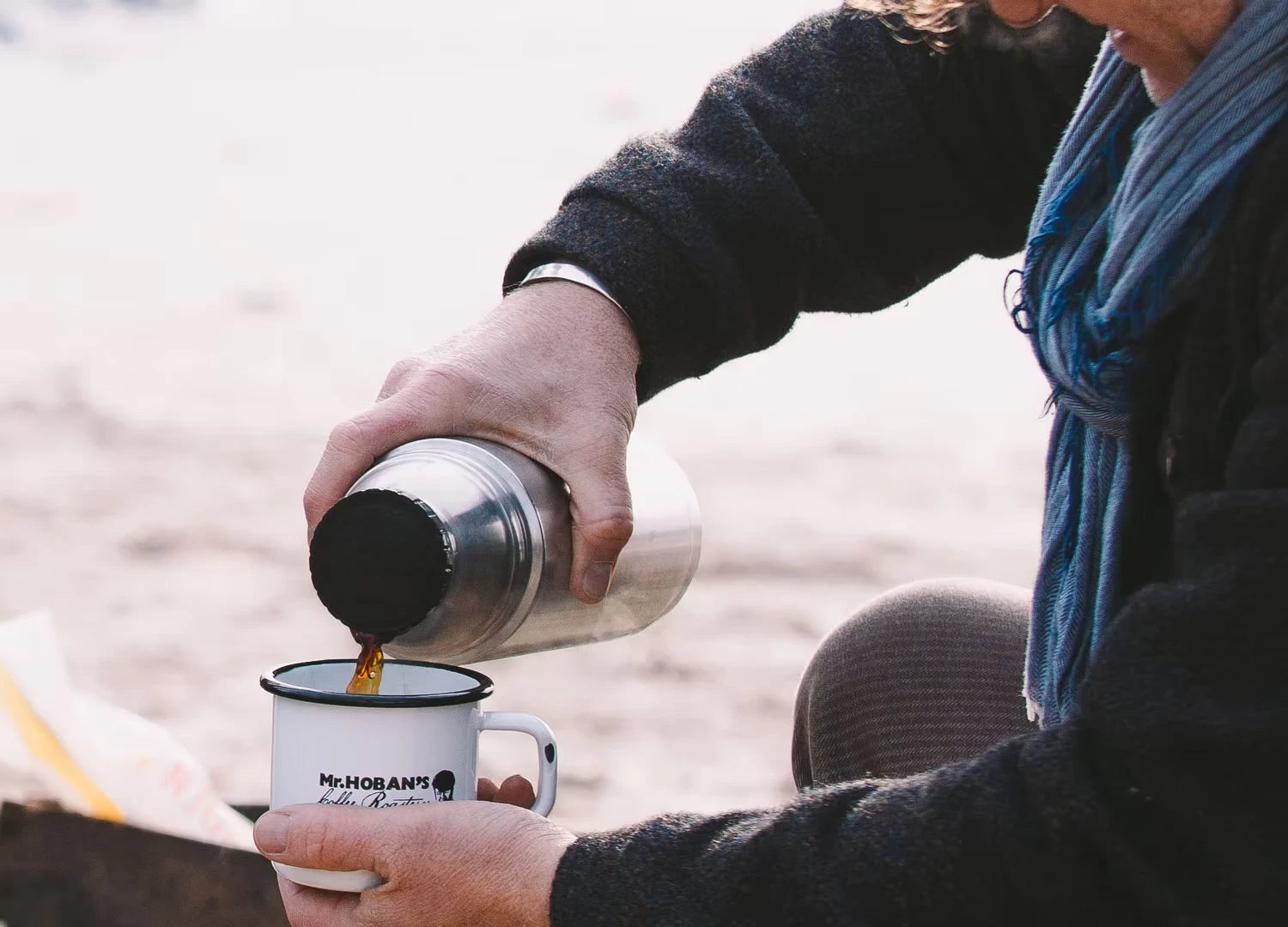 Kaffee wird aus einer Thermoskanne in einen Mr. Hoban's Emaillebecher gegossen